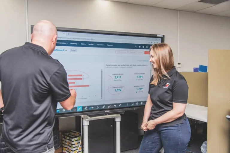 Man and woman analyzing data on an interactive touch screen in an office