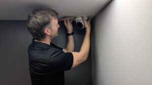 man installing a security cctv camera in an office