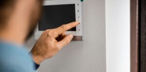 Person touching an access control panel on a wall
