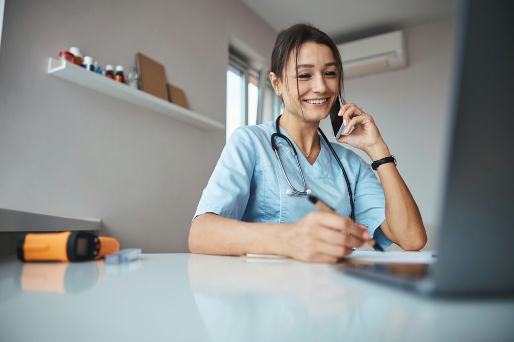 Healthcare worker on the phone in an office smiling