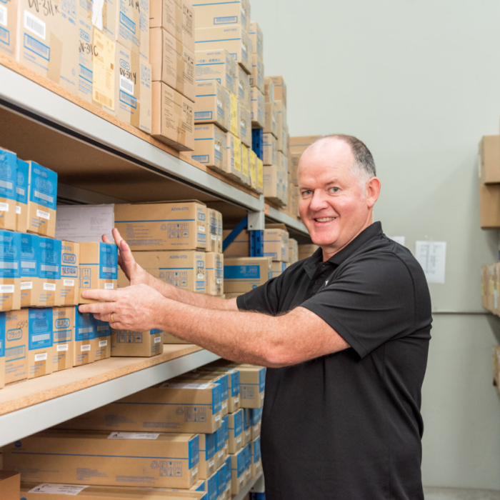 Man organizing boxes on shelves in a storage room