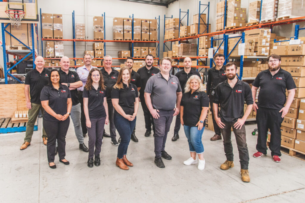 Kiss professional solutions team of about 25 people stood in front of the warehouse