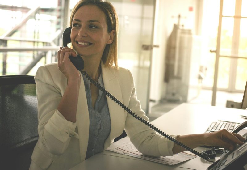 getty-images-0uEDeszsKvk-unsplash Woman at her desk using a phone system